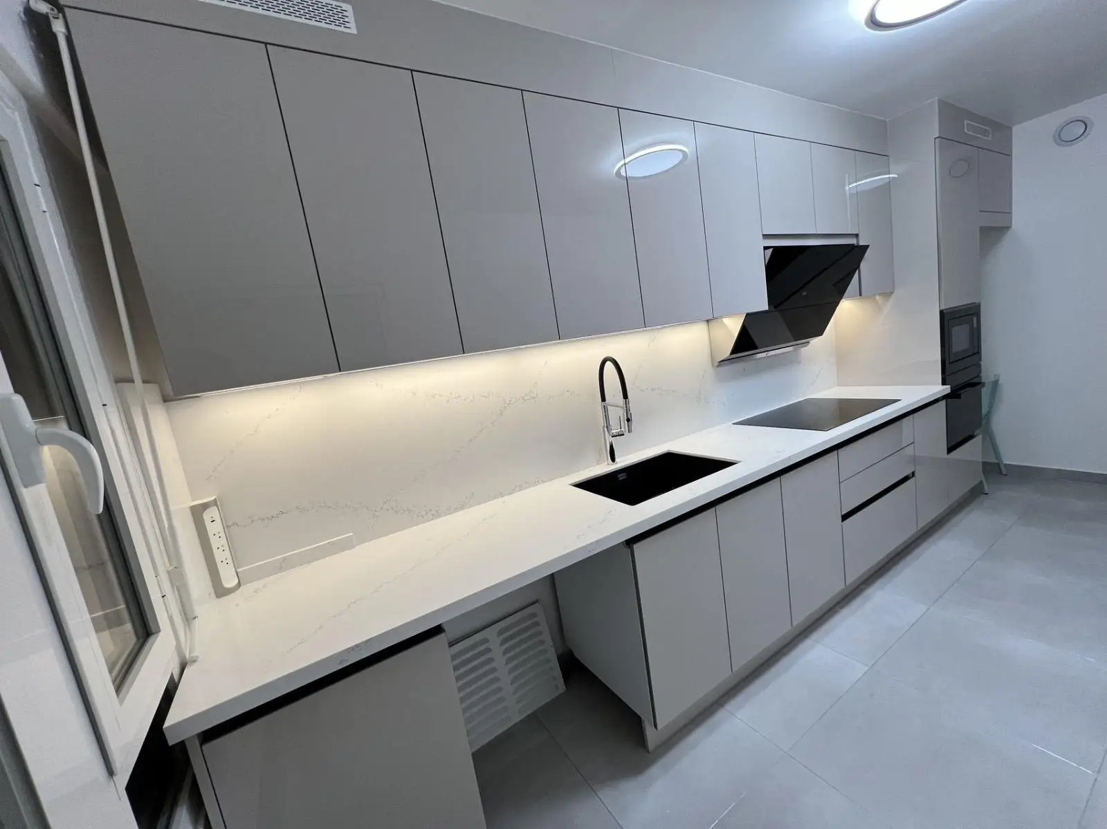 Repeating fitted kitchen run in matt lacquer with stone worktop