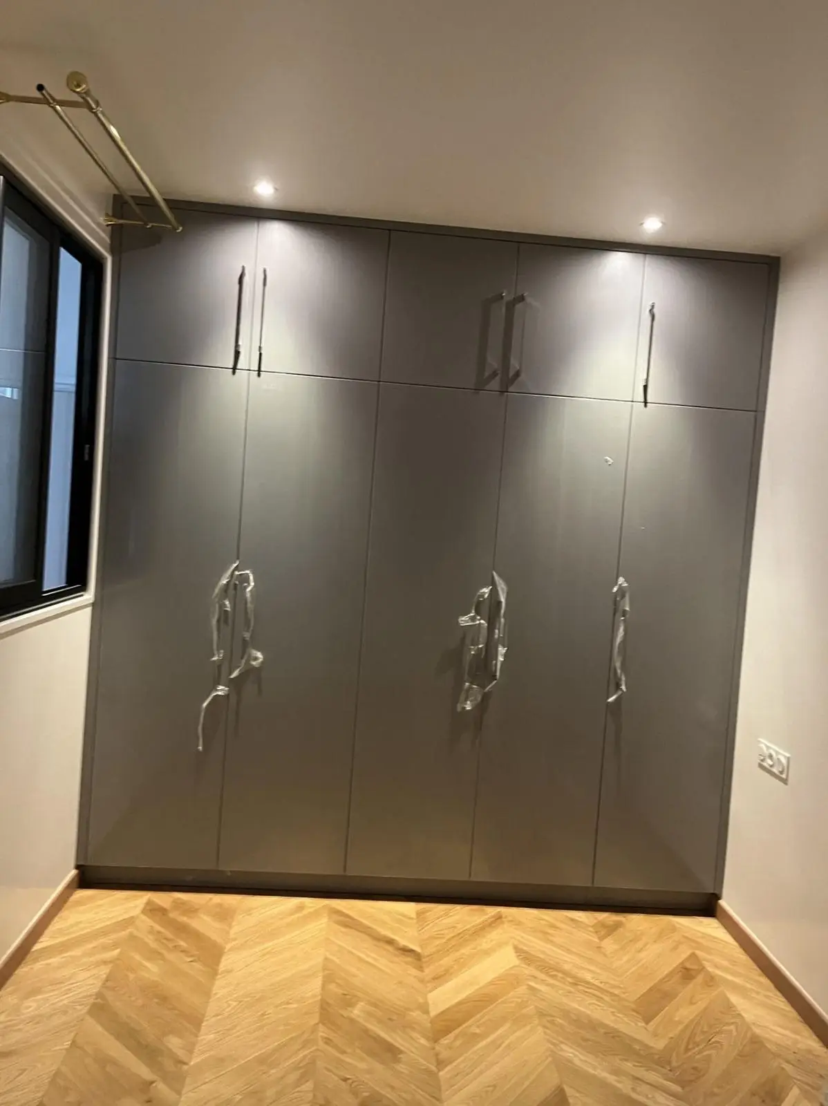 Fitted wardrobe fronts in matt lacquer with full-height handles