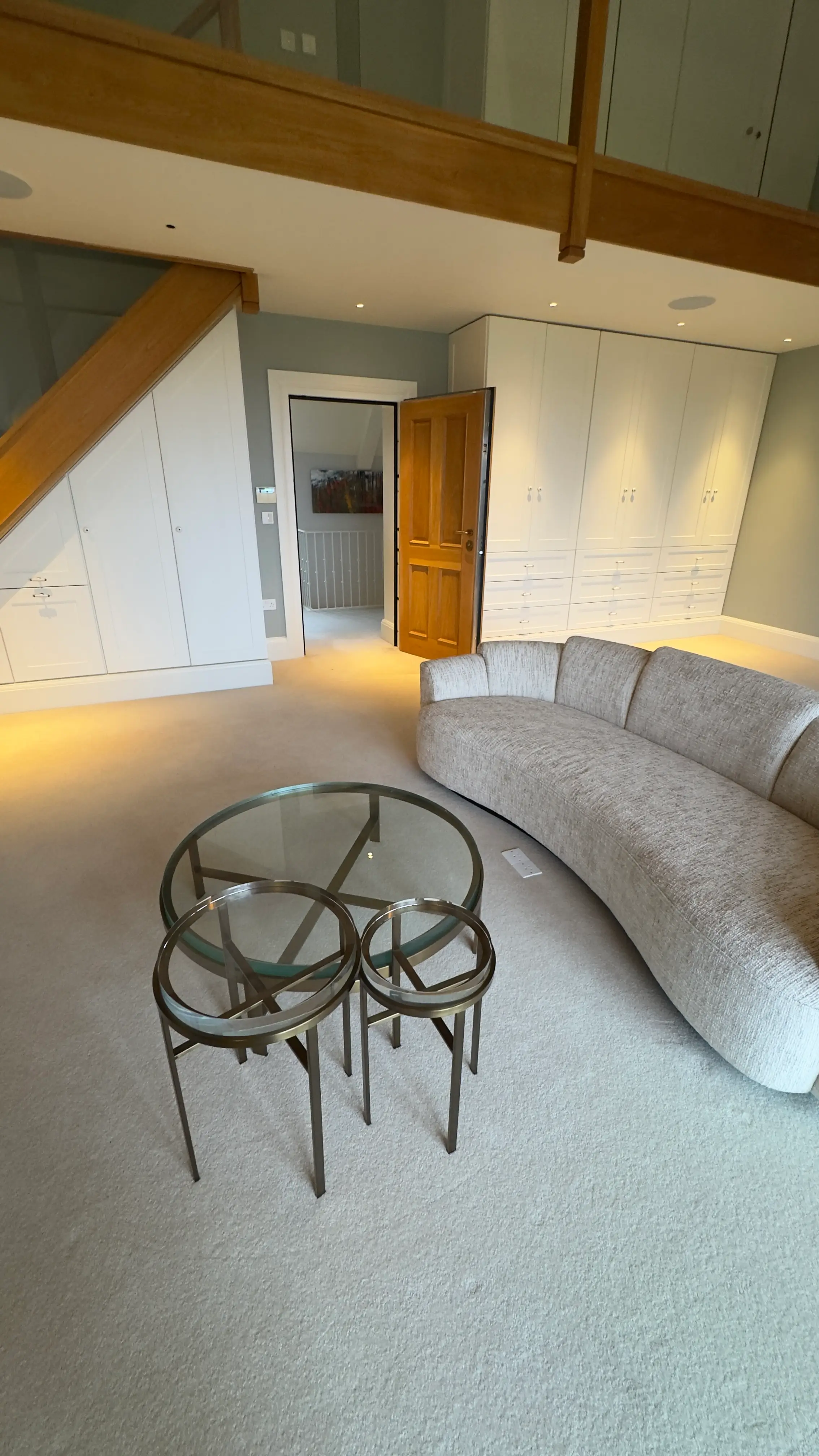 Curved sofa with nested glass and metal occasional tables