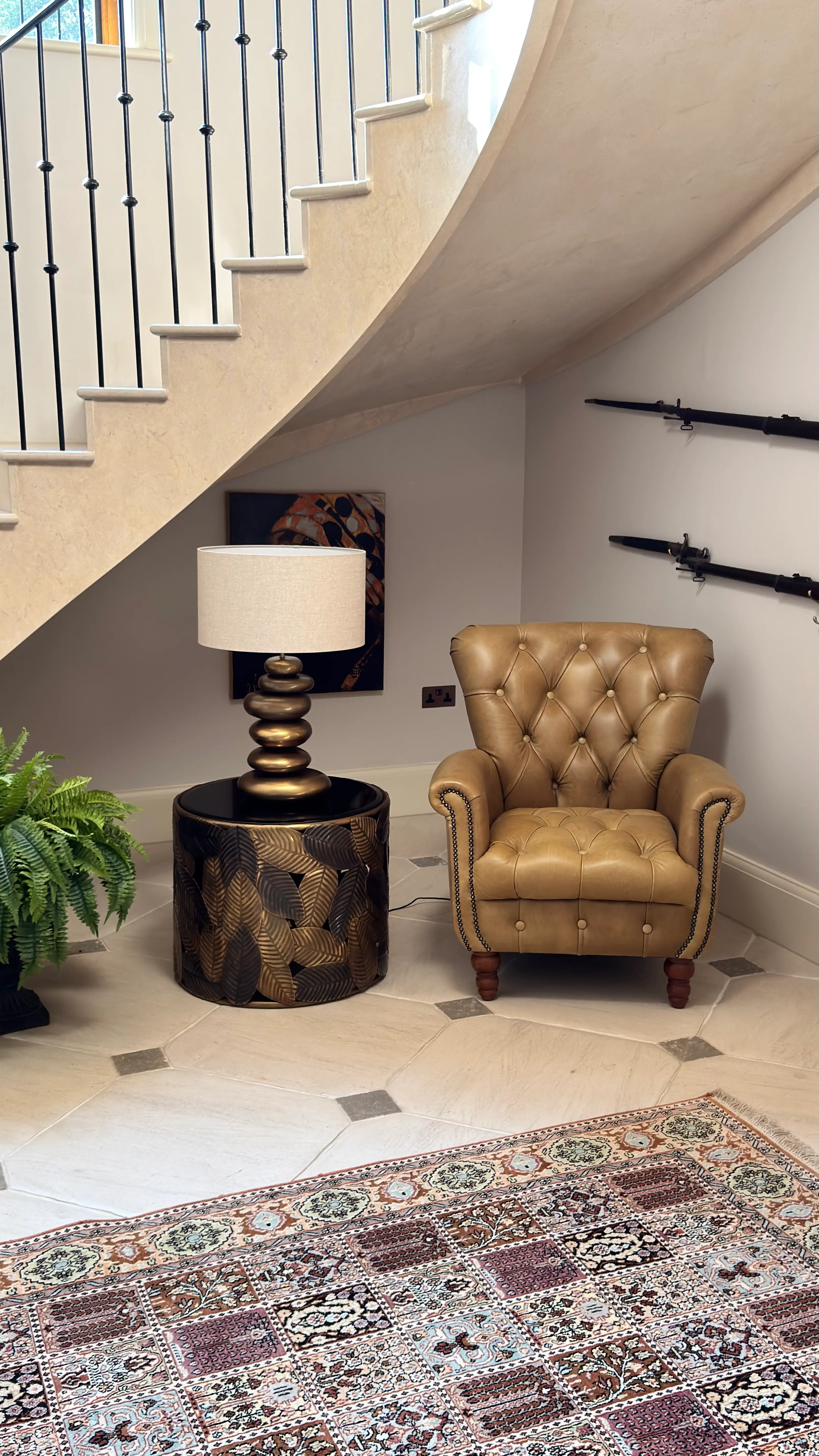 Buttoned leather armchair beside a sculptural table lamp