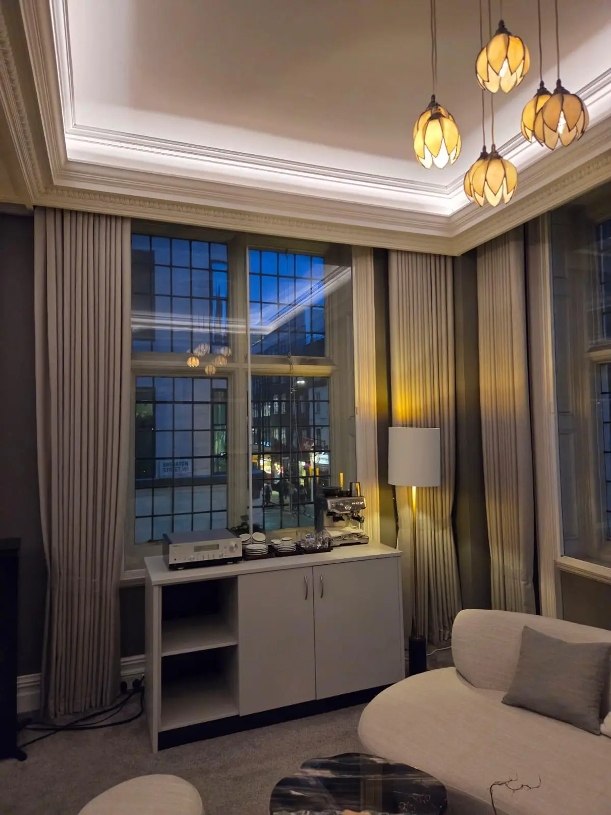 Floor lamp and full-height curtains at a Crittall window, with the boardroom seating beyond